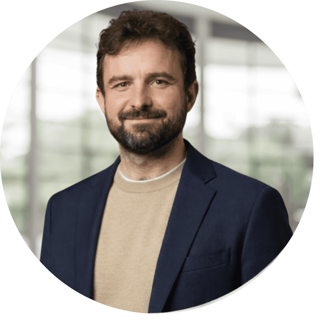 Homem de negócios sorridente em ambiente corporativo.